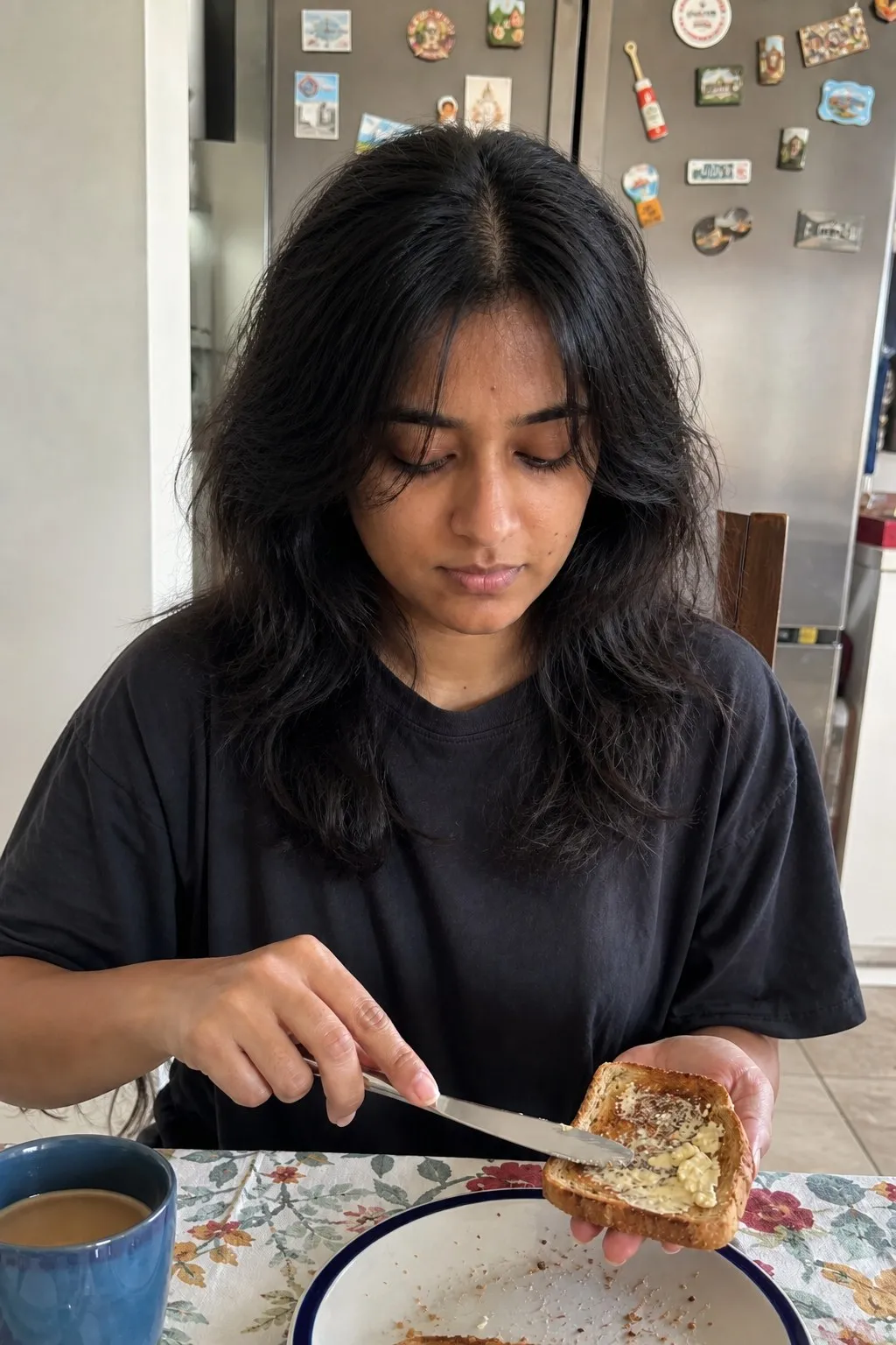 A woman buttering toast at a kitchen table before and after a wolf cut