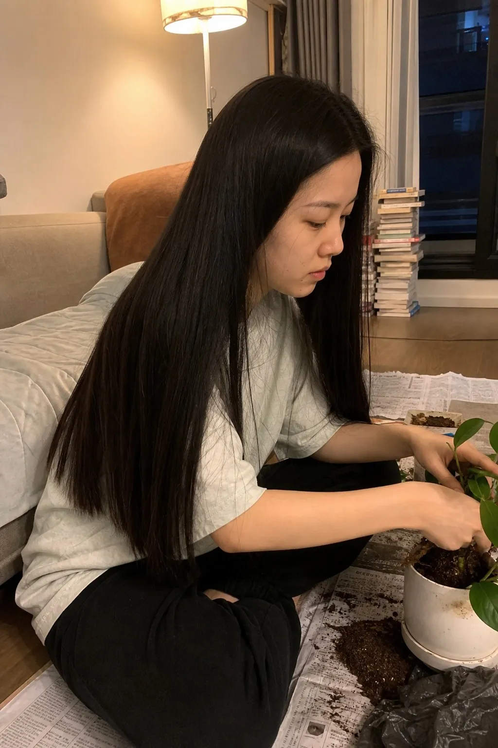 A woman repotting a plant on her apartment floor before and after a layered shag - before